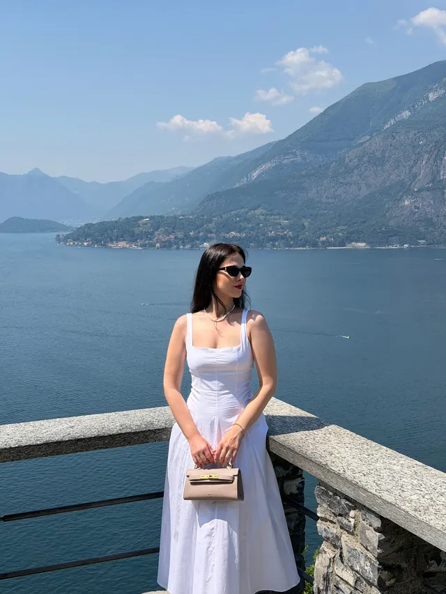 Karolina in a white dress on a terrace above Lake Como