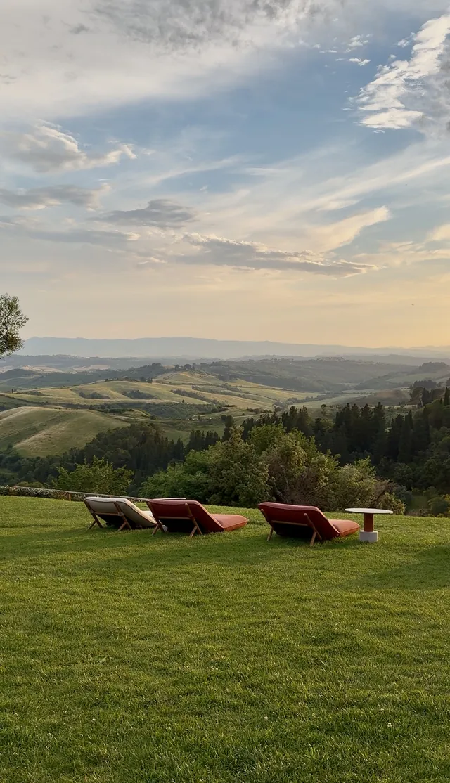 Sun loungers on a lawn overlooking the countryside at sunset